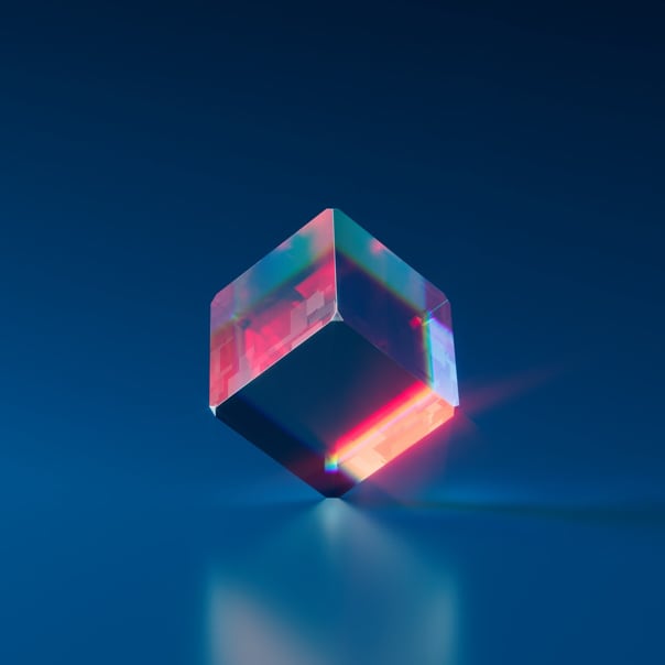 A glass cube standing on one of it's corners with light reflecting off of the cube.